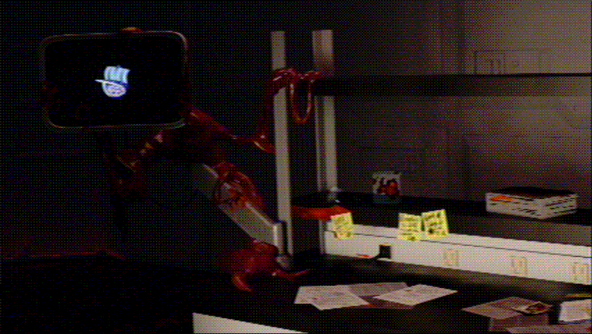 View of a monitor attached to an arm stand on a lab table, covered in viscera and scattered notes